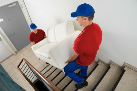 Zwei Männer tragen Sofa runter